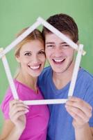 pareja feliz pintando una pared en su nuevo hogar foto