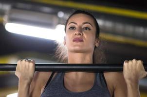 mujer haciendo pull ups en la barra horizontal foto