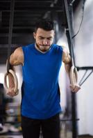 man working out pull ups with gymnastic rings photo