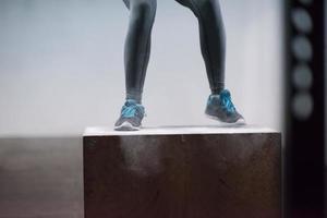 mujer negra está realizando saltos de caja en el gimnasio foto