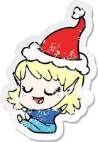 happy distressed sticker cartoon of a elf girl sitting wearing santa hat vector