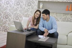 young couple working on laptop at home photo