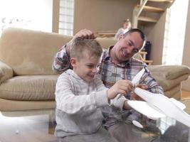 father and son assembling airplane toy photo