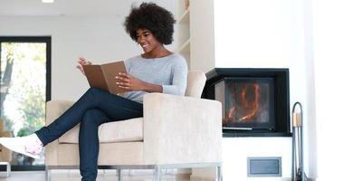 mujer negra en casa leyendo un libro foto