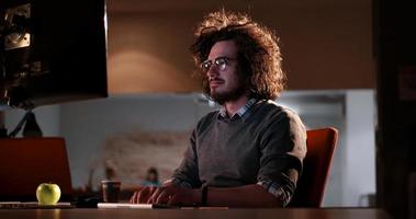 man working on computer in dark office photo