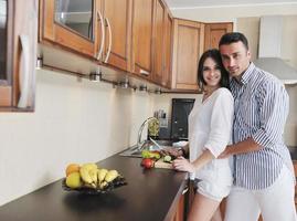 feliz pareja joven divertirse en la cocina moderna foto