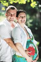 Happy pregnant couple at beautiful sunny day in park photo