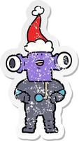 friendly distressed sticker cartoon of a alien wearing santa hat vector