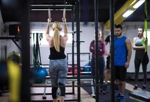 mujer trabajando con entrenador personal en anillos de gimnasia foto