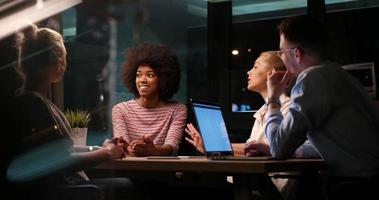 Multiethnic startup business team in night office photo