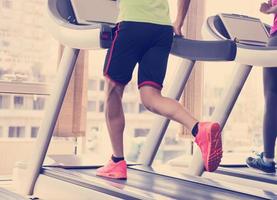 people exercisinng a cardio on treadmill in gym photo