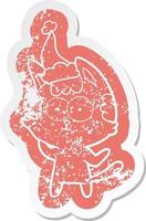 happy cartoon distressed sticker of a cat wearing santa hat vector