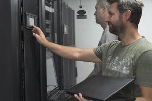 Technicians team updating hardware inspecting system performance in super computer server room or cryptocurrency mining farm. photo