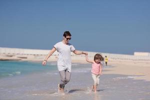 mother and daughter running on the beach photo