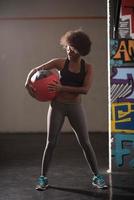 black woman carrying crossfit ball photo