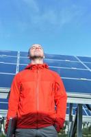 engineer using laptop at solar panels plant field photo