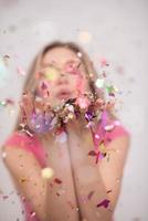 woman blowing confetti in the air photo