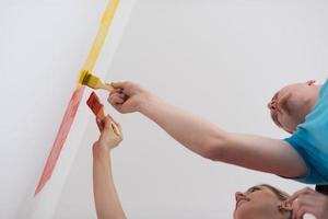 couple painting interior wall photo