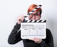 redhead woman holding movie  clapper on white background photo