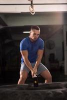 man workout with hammer and tractor tire photo