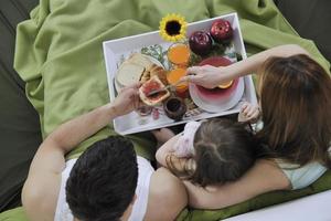 familia joven feliz desayunar en la cama foto