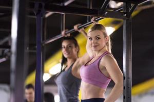 young athletes doing pull ups on the horizontal bar photo