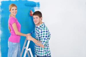 happy couple paint wall at new home photo