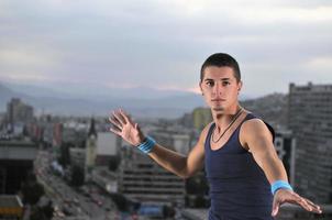 young man dancing and jumping  on top of the building photo