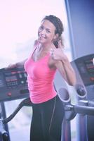 mujer haciendo ejercicio en cinta de correr en el gimnasio foto