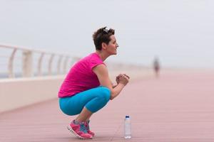 mujer estirándose y calentándose en el paseo marítimo foto