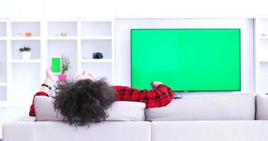 Young couple on the sofa watching television photo