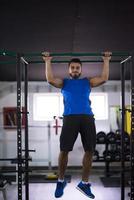 man doing pull ups on the horizontal bar photo