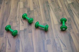 green dumbbells on patquet floor photo