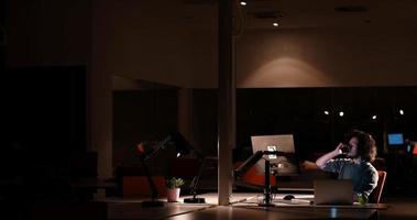 man working on computer in dark office photo