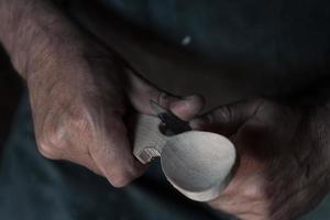 Spoon craft master in his workshop with handmade wooden products and tools working photo