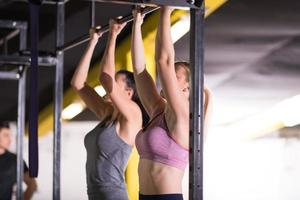 young athletes doing pull ups on the horizontal bar photo