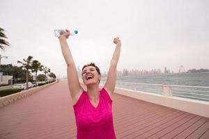 mujer joven celebrando una carrera de entrenamiento exitosa foto