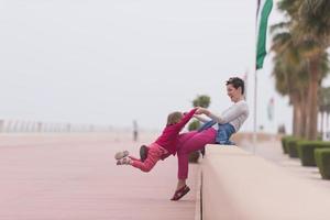 mother and cute little girl on the promenade by the sea photo