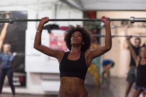 mujer negra levantando barra vacía foto