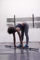 black woman lifting empty bar photo