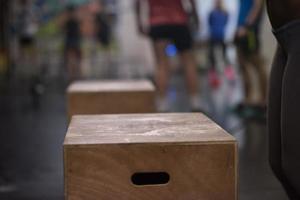 black woman is performing box jumps at gym photo