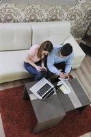 young couple working on laptop at home photo