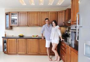 happy young couple have fun in modern kitchen photo