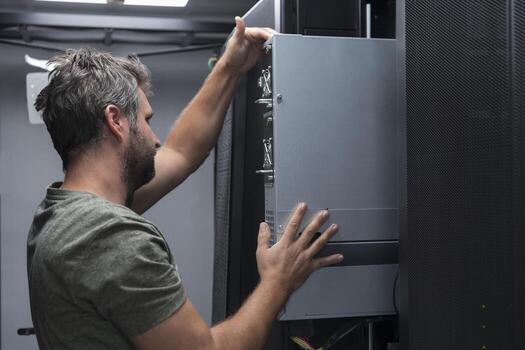IT engineer working In the server room or data center The technician puts in a rack a new server of corporate business mainframe supercomputer or cryptocurrency mining farm. photo