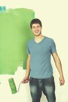 handsome young man paint white wall in color photo