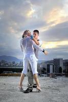 pareja urbana romántica bailando en la parte superior del edificio foto