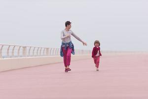 madre y niña linda en el paseo marítimo junto al mar foto