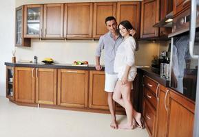 feliz pareja joven divertirse en la cocina moderna foto