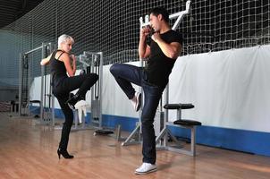 woman in the fitness gim working out with personal trainer photo