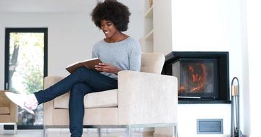 mujer negra en casa leyendo un libro foto